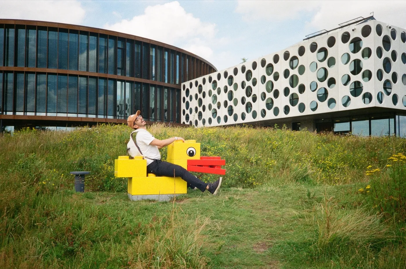 Hank sitting on a giant LEGO duck outside the LEGO House in Billund
