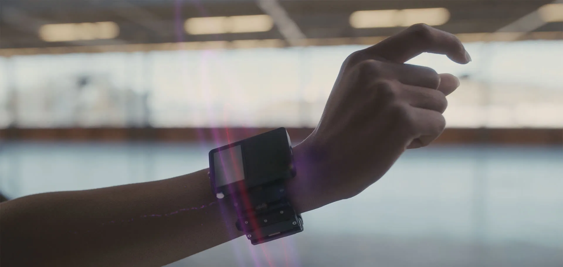 A wrist-worn research prototype on a forearm, the hand mid-gesture, with visualized input fields around the wrist